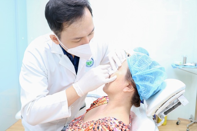 Bác sĩ Bệnh viện Da Liễu TP HCM tiêm botox xoá nhăn đuôi mắt cho khách hàng. Ảnh: Lan Anh