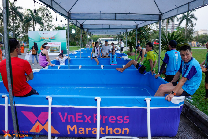 Các runner ngâm chân ở khu vực bồn nước đá sau khi tham dự VnExpress Marathon Imperial Huế 2022. Ảnh: Phạm Chiểu