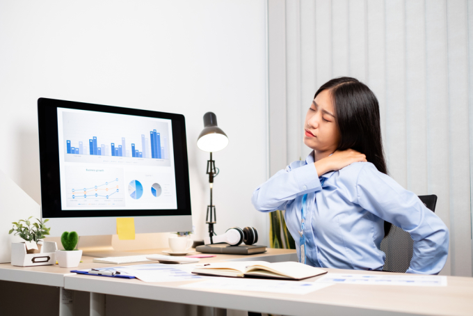 Ngồi một chỗ quá lâu khiến nhân viên văn phòng dễ bị đau cổ, vai gáy. Ảnh: Shutterstock