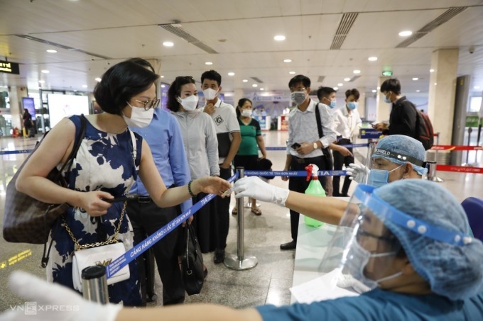 Hành khách tại sân bay Tân Sơn Nhất xếp hàng chuẩn bị lấy mẫu xét nghiệm Covid-19 hồi tháng 5/2021. Ảnh:Hữu Khoa
