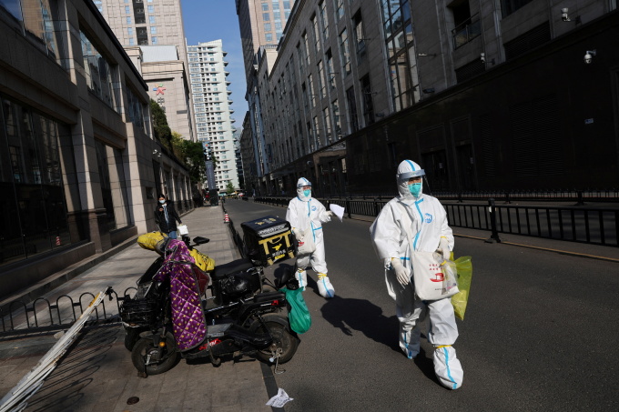 Nhân viên mặc đồ bảo hộ trên đường phố quận Triều Dương, Bắc Kinh, Trung Quốc, hôm 9/5. Ảnh: Reuters.