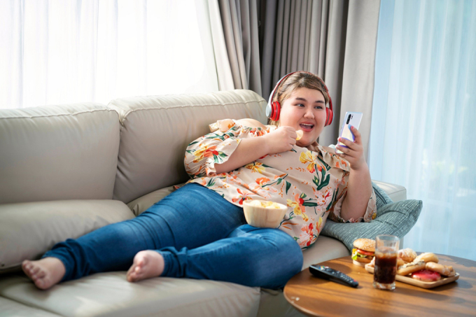 Tăng cân do ăn uống không kiểm soát, lối sống lười vận động. Ảnh: Shutterstock