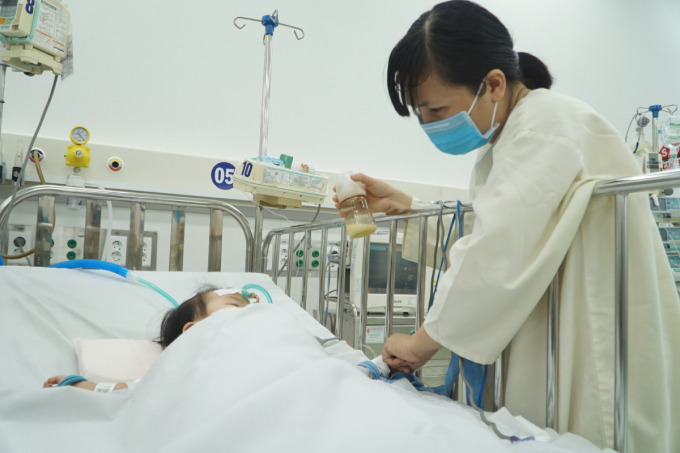 Chị Tường Vi, 35 tuổi, ở Bình Dương mang theo sữa vào thăm con gái bị sốc sốt xuất huyết tại khoa ICU, Bênh viện Nhi đồng Thành phố. Ảnh: Thư Anh