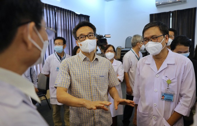 Phó Thủ tướng Vũ Đức Đam (áo sơ mi) trao đổi với bác sĩ Bệnh viện Bệnh Nhiệt đới TP HCM về tình hình điều trị sốt xuất huyết, sáng 30/6. Ảnh: Quỳnh Trần