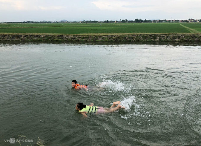 Trẻ em ở Thanh Hóa học bơi trên kênh đào thủy lợi có sự giám sát của người lớn. Ảnh: Hồng Chiêu