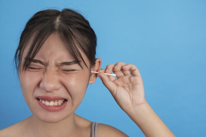 Dùng tăm bông ráy tai quá sâu có thể gây đau, giảm thính lực. Ảnh: Freepik