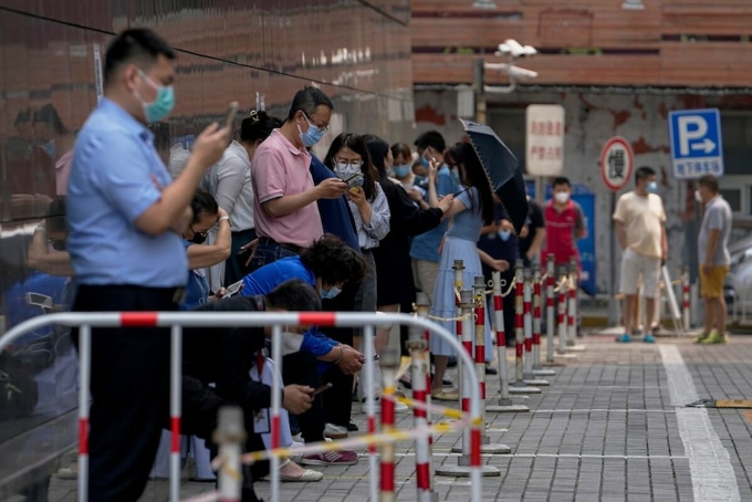 Người dân đeo khẩu trang xếp hàng tại một điểm xét nghiệm Covid-19 ở Bắc Kinh, Trung Quốc, ngày 16/6. Ảnh: AP