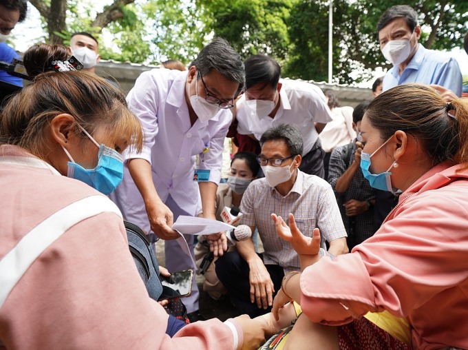 Phó Thủ tướng Vũ Đức Đam (áo sơ mi) trao đổi với thân nhân, bệnh nhân sốt xuất huyết và các bác sĩ Bệnh viện Bệnh Nhiệt đới TP HCM, sáng 30/6. Ảnh: Quỳnh Trần