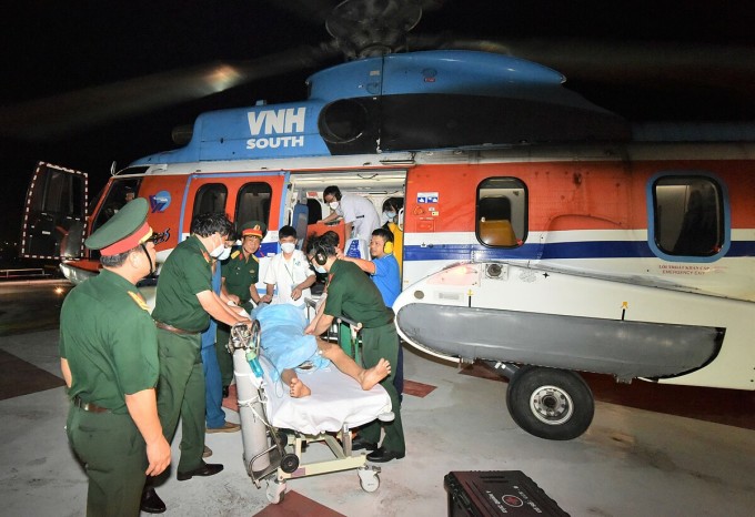 Bệnh nhân được chuyển xuống khu điều trị Bệnh viện Quân y 175 khi trực thăng hạ cánh trên nóc bệnh viện. Ảnh: Chính Trần