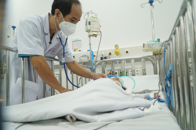 Bác sĩ Phạm Văn Quang thăm khám cho một trẻ nhũ nhi bị sốc sốt xuất huyết. Ảnh: Thư Anh