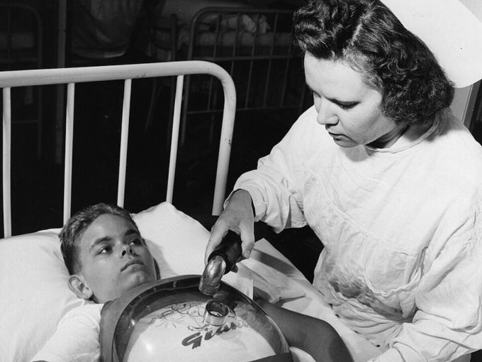 Bệnh nhân bại liệt được lắp máy thở ở ngực để có thể hô hấp bình thường. Ảnh: Hulton Archive