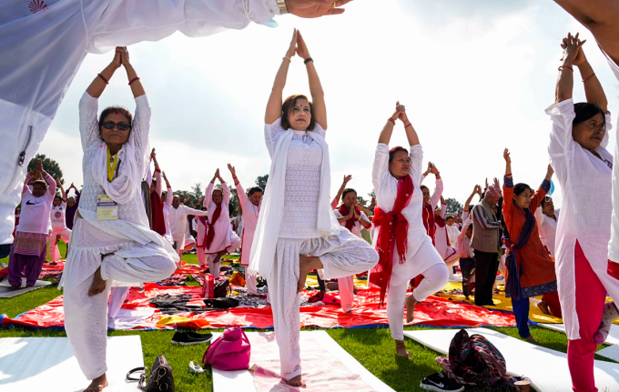 Người dân đứng trên một chân khi tập yoga tại Kathmandu, Nepal, vào ngày 21/6. Ảnh: AP