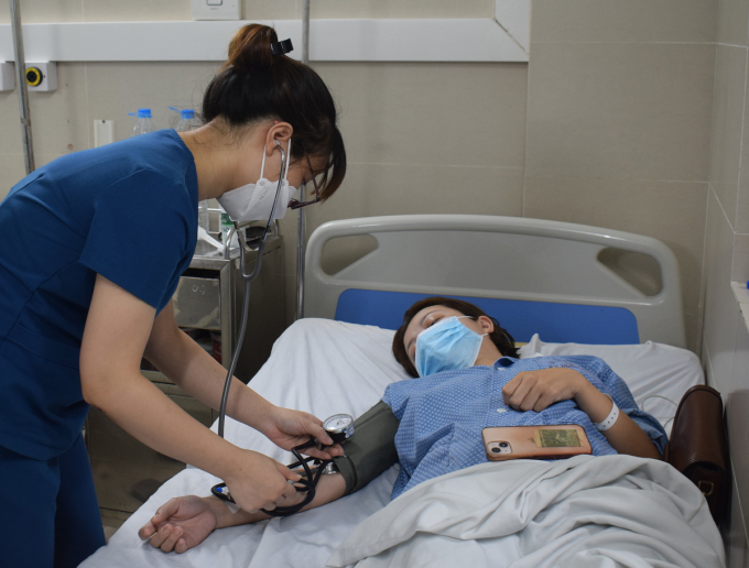 Điều dưỡng đo huyết áp cho bệnh nhân cúm A nhập viện tại Bệnh viện Đa khoa Thanh Nhàn, ngày 6/7. Ảnh:Chi Lê