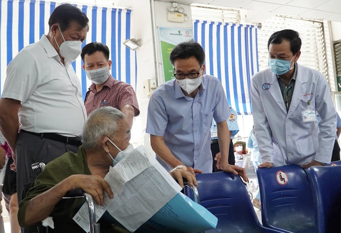 Phó thủ tướng Vũ Đức Đam (áo sơ mi xanh) thăm hỏi người bệnh tại khu vực nhà thuốc Bệnh viện Chợ Rẫy, chiều 30/6. Ảnh: An Mỹ
